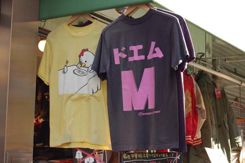 I particularly like the chicken and egg t-shirt and how it makes us try to imagine what the chicken is feeling. The pink DOEM M t-shirt: M is for Masochist and the top three characters are the katakana for DO E M. Do means strong. I guess you could translate it as big time masochist. I saw an S t-shirt too.